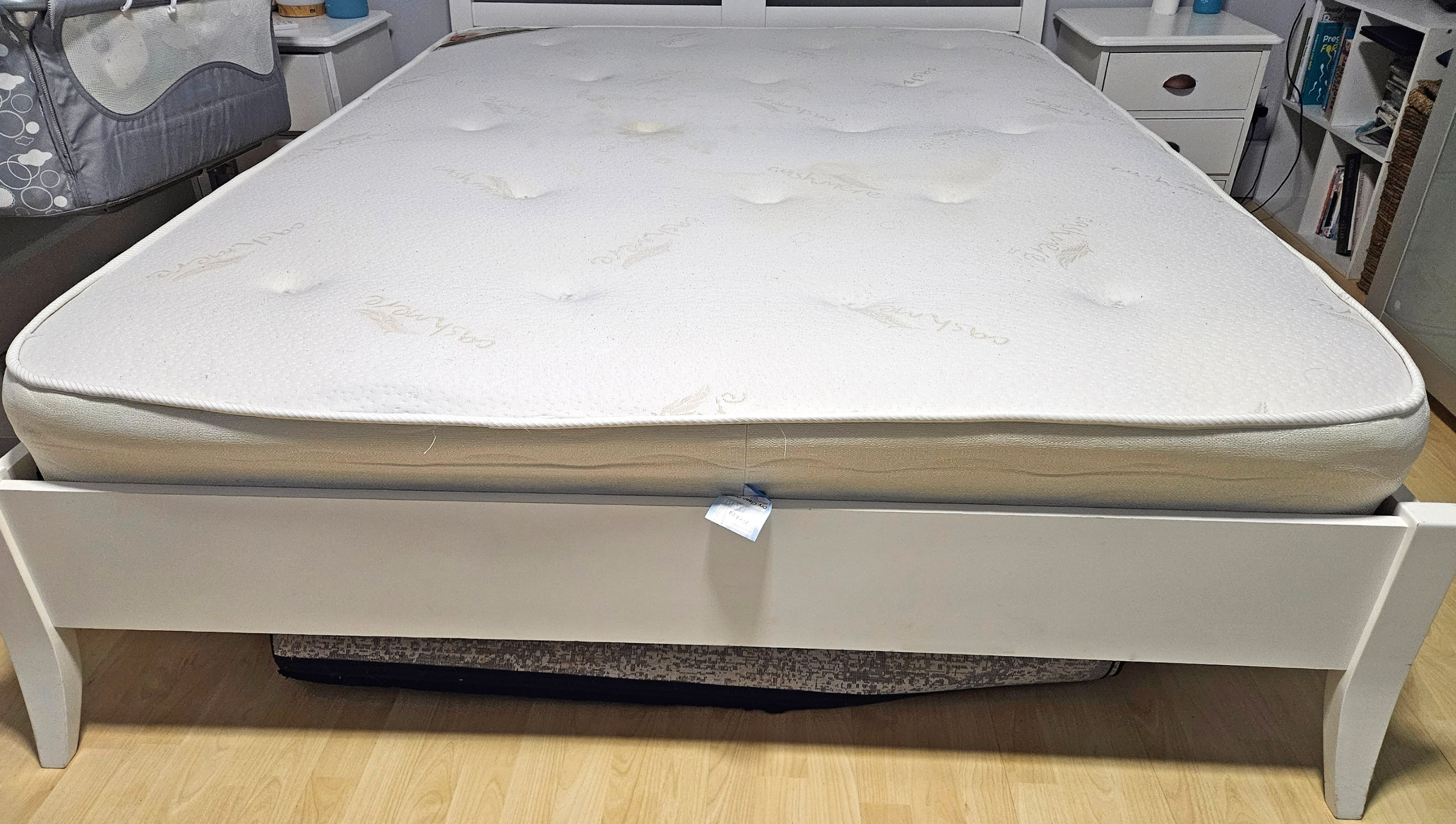 Old mattress full view on bed frame